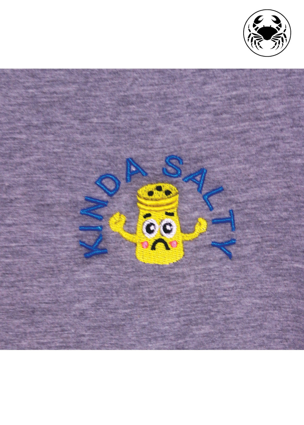 Close-up of embroidered “Kinda Salty” salt shaker design on grey cotton t-shirt