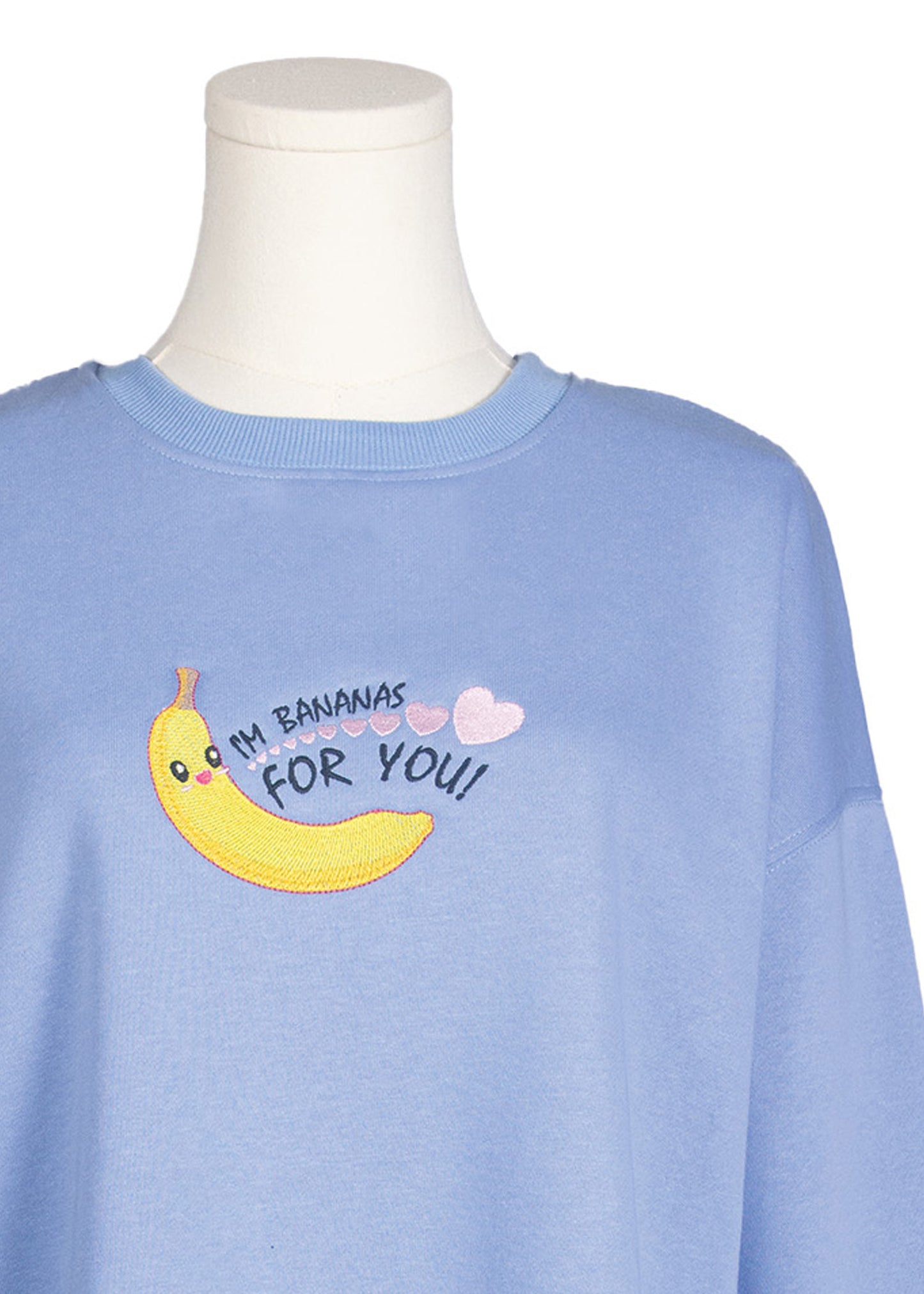 Close-up of pastel blue sweatshirt with embroidered cartoon banana and “I’m Bananas For You!” cute design, Canadian apparel