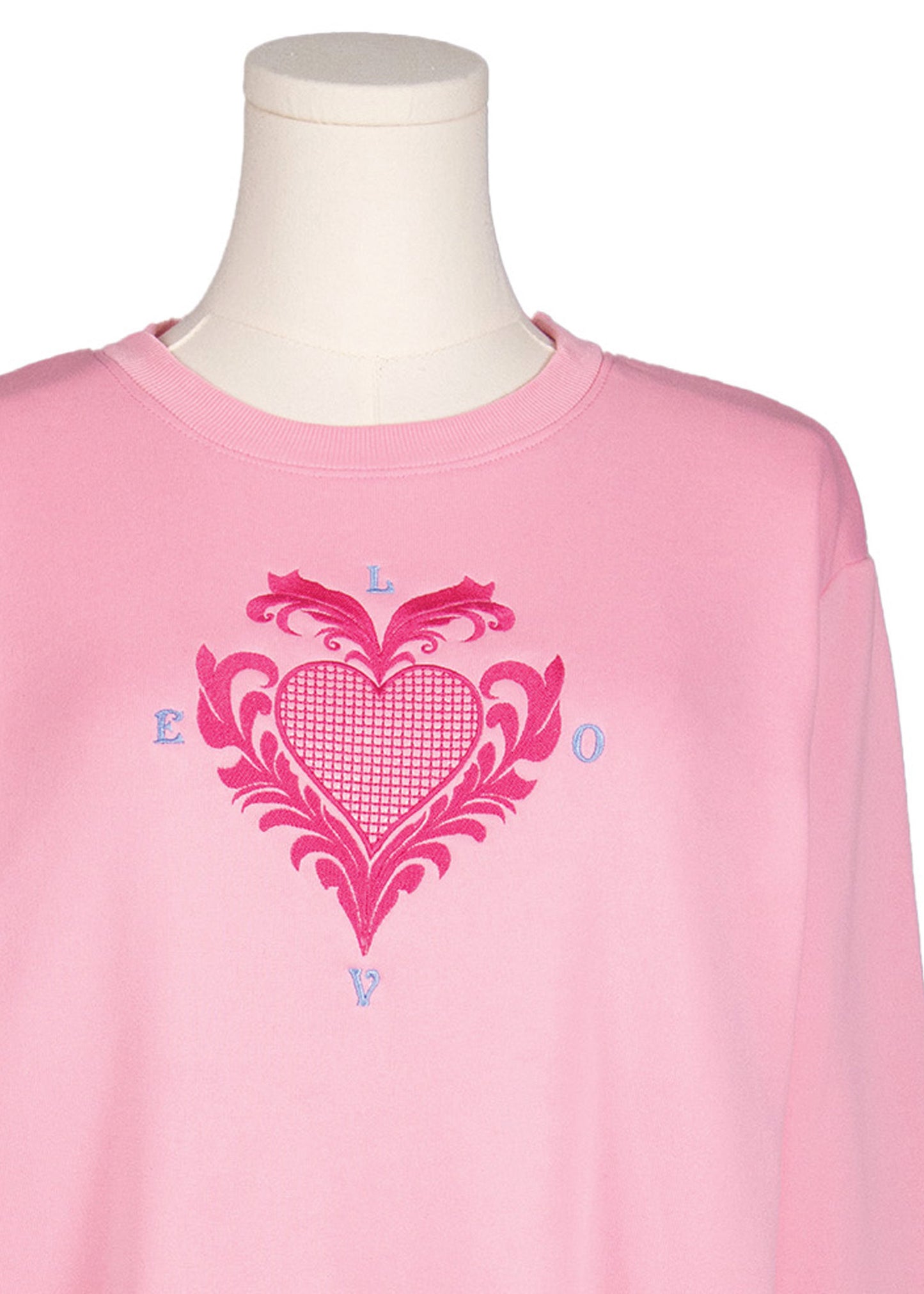 Close-up of pink sweatshirt with embroidered Victorian style heart and “Love” design, Canadian apparel