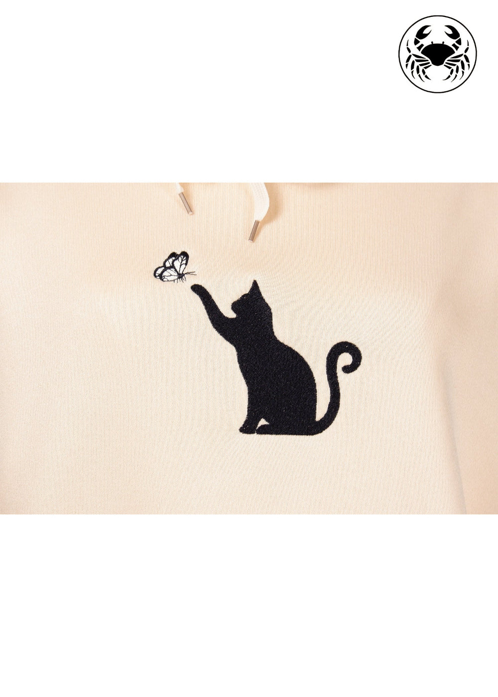 embroidery close up view of Unisex beige hoodie with a front kangaroo pocket, drawstring hood, and an embroidered chest design featuring a Cat Caught in a Moment with Butterfly