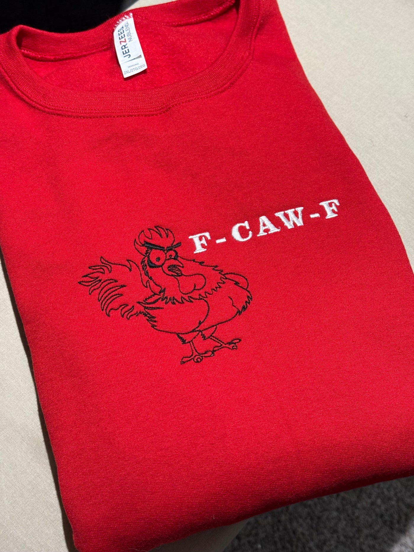 front view of Red sweatshirt with a graphic rooster meme design embroidery