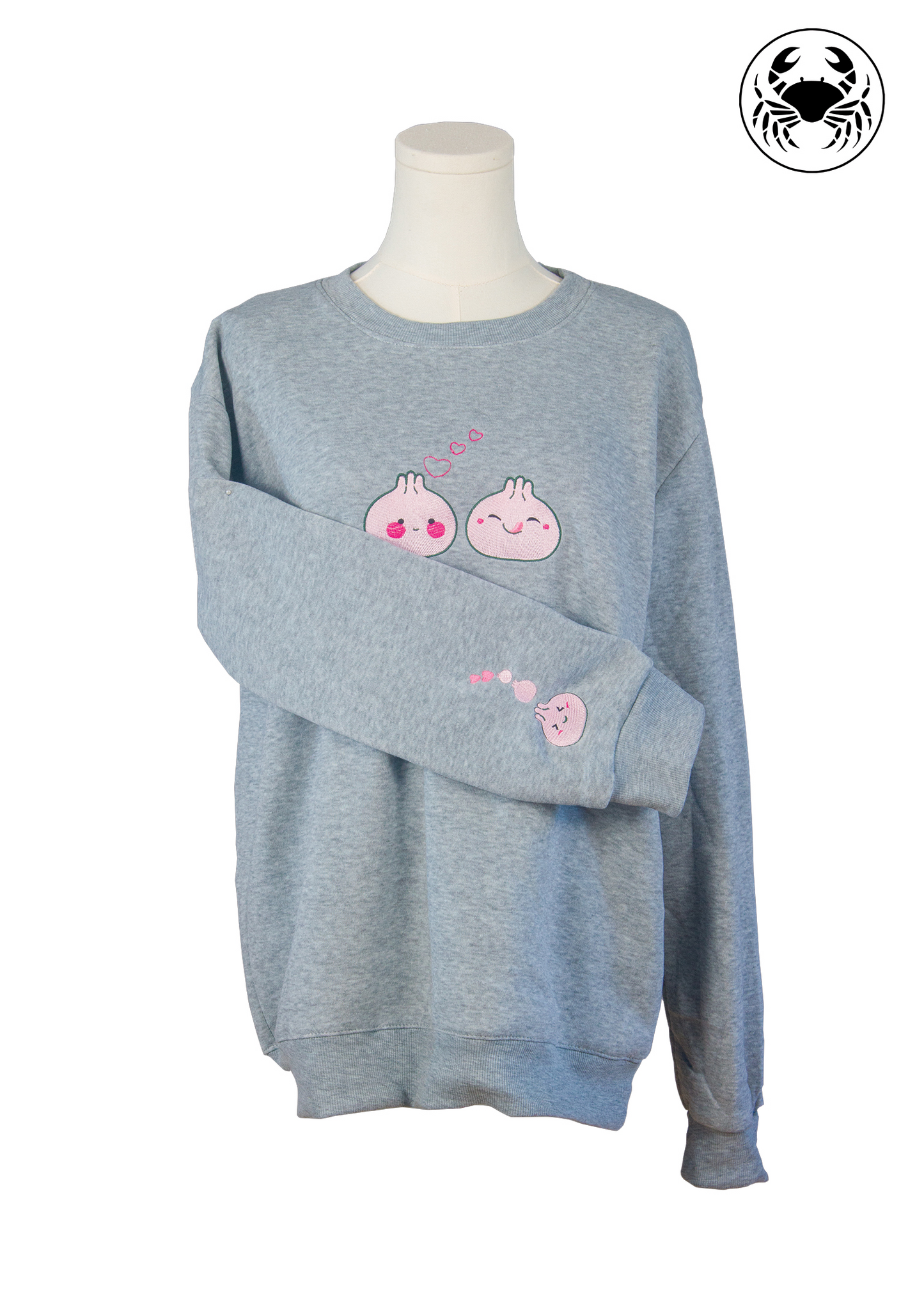 close-up view of Sleeve showing pink dumpling embroidery with hearts on grey unisex sweatshirt
