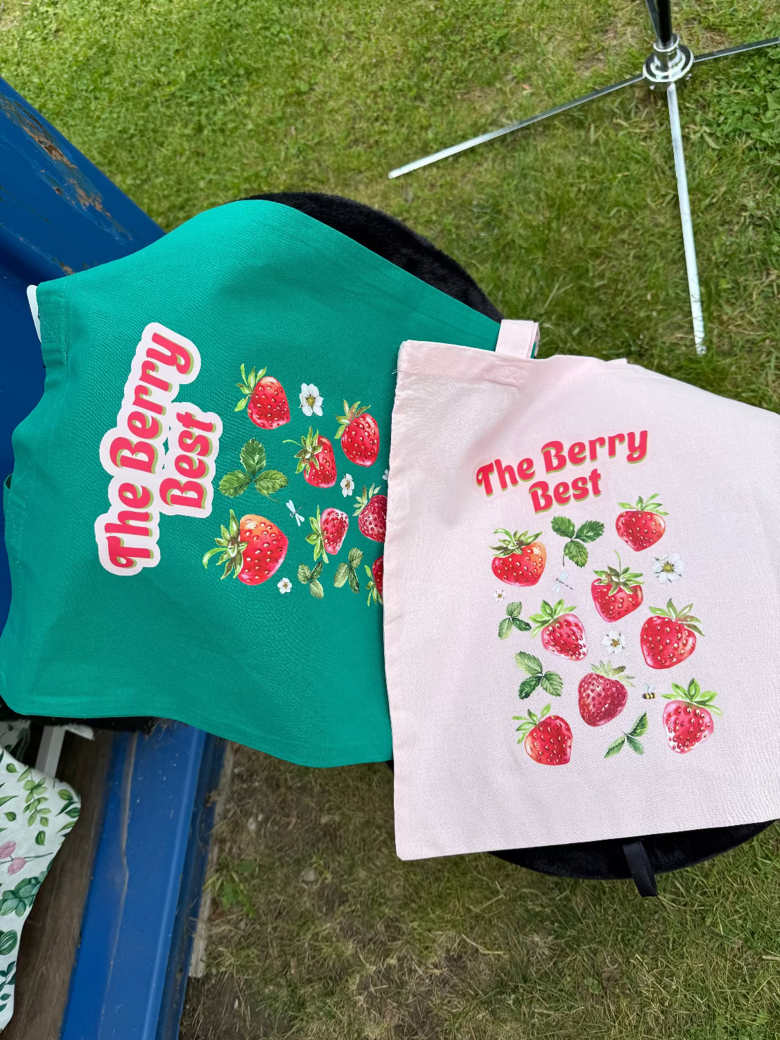 Two tote bags with "The Berry Best" text printed on them lying next to each other