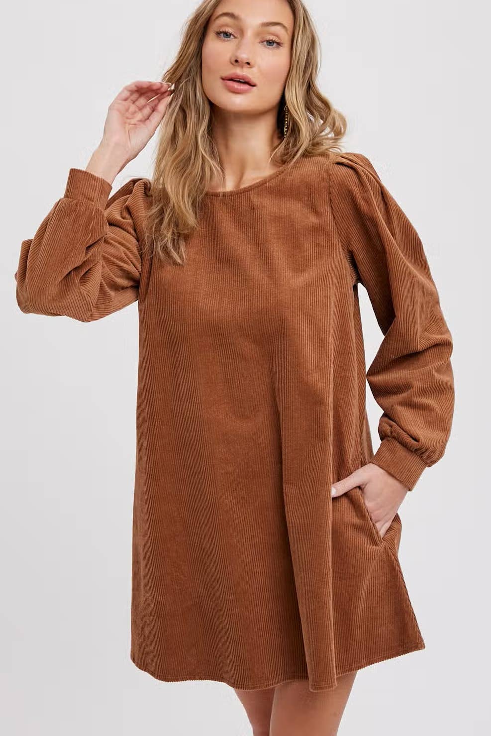 Women's camel corduroy dress with long balloon sleeves and side pockets close up