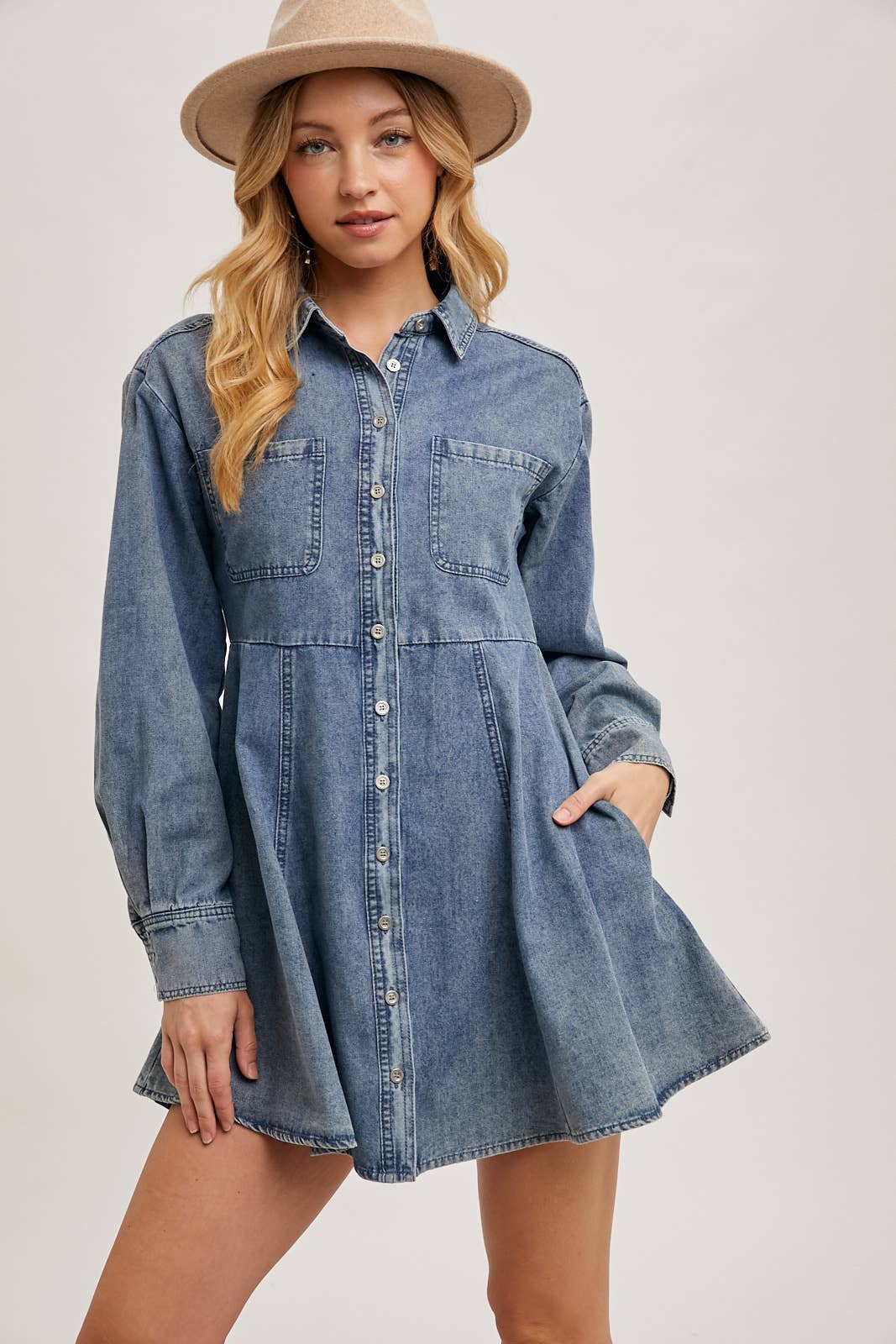 front view of denim shirt dress with hands in pockets, A-line fit, relaxed casual styling