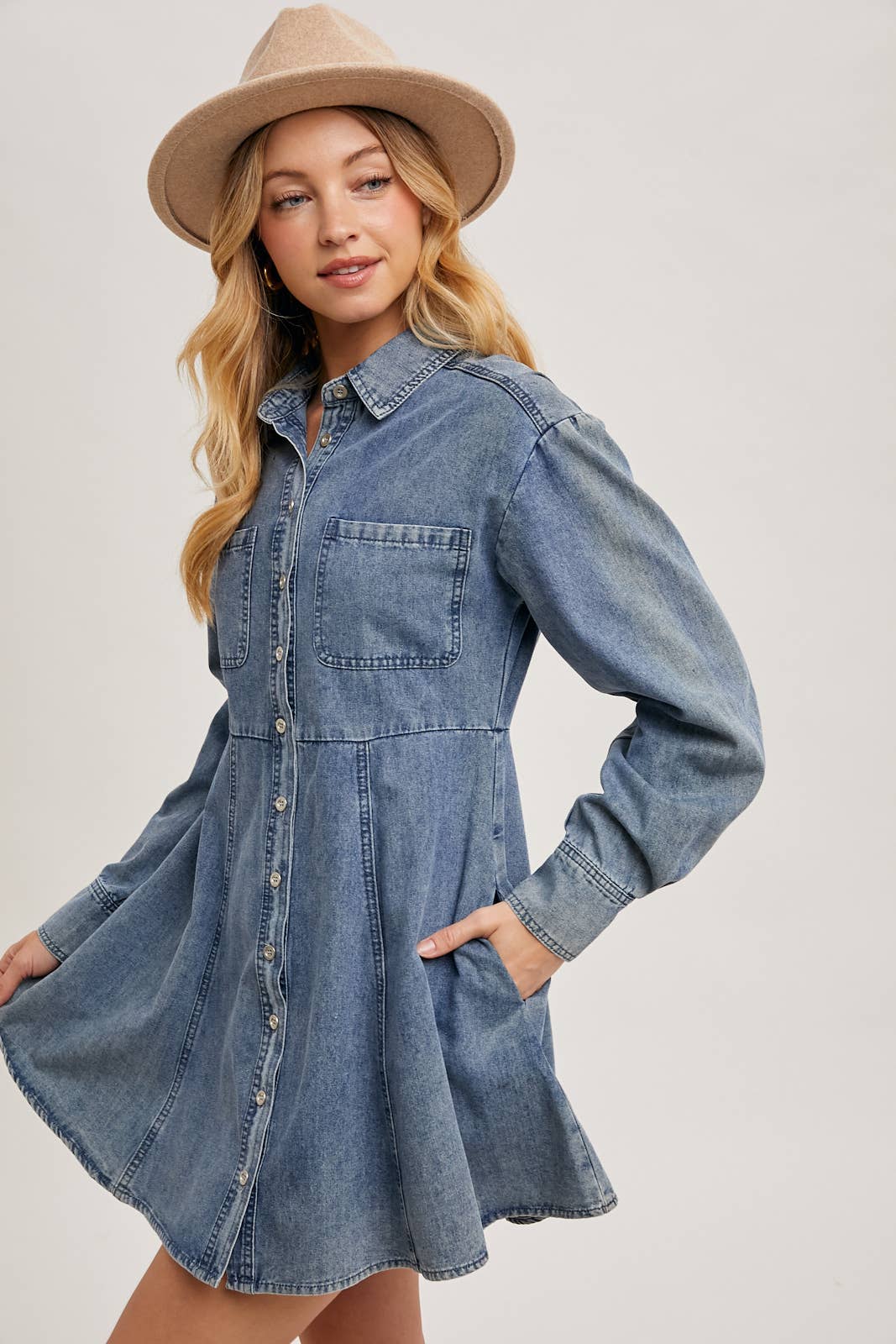 Denim shirt dress side pose, highlighting button-down detail, front pocket, and model profile
