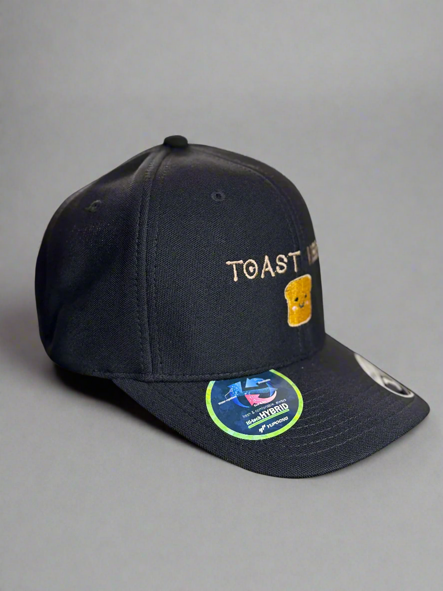 Angled side view of black Toast Vibes dad hat with sticker detail