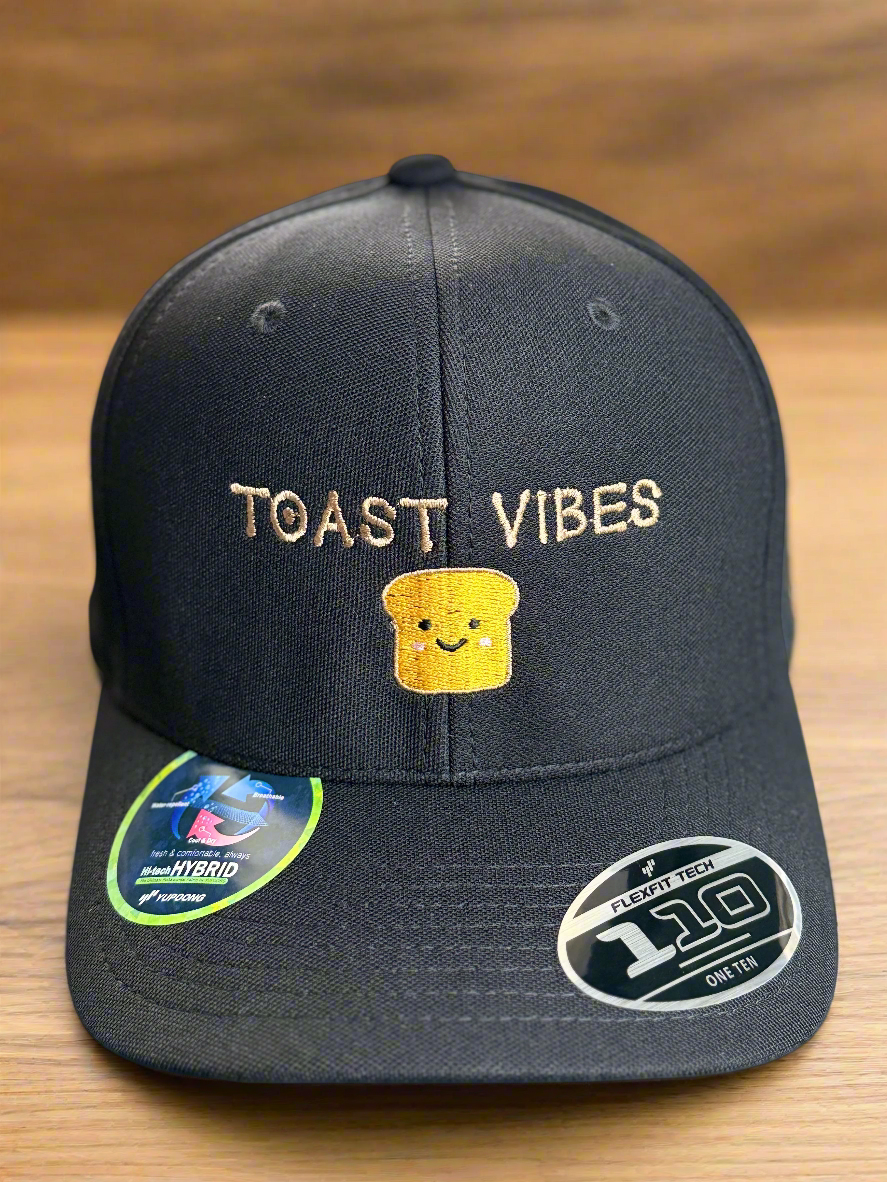 Black hat with “Toast Vibes” text and smiling toast embroidery on front