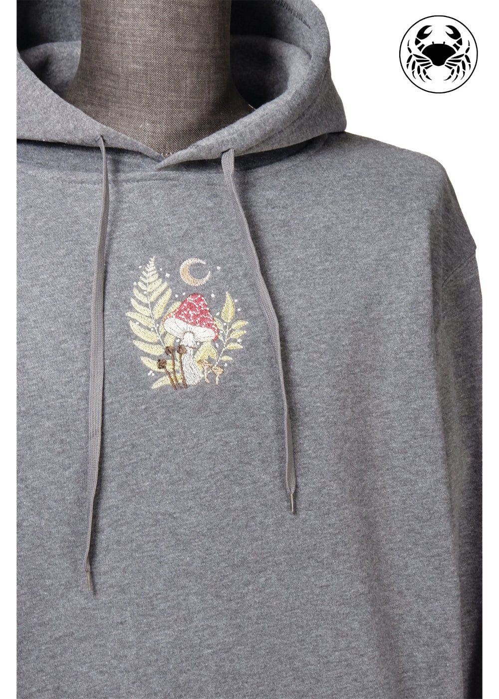 Unisex charcoal gray fleece hoodie with a front kangaroo pocket, drawstring hood, and a chest graphic featuring a mushroom and botanical leaves