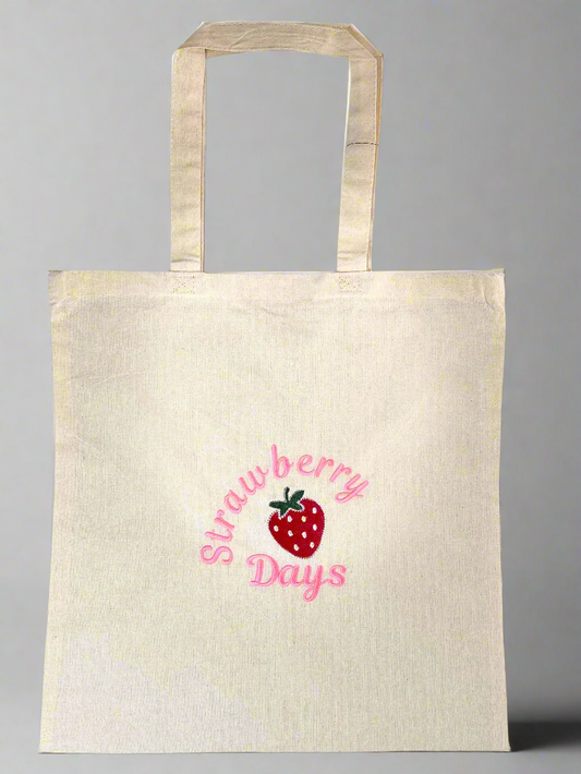 Natural cream cotton tote bag with pink 'Strawberry Days' embroidery and a red strawberry design