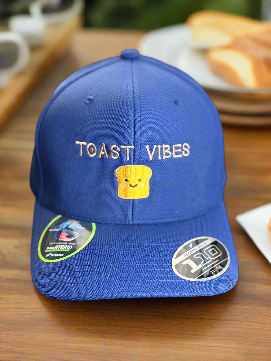 Royal blue hat with “Toast Vibes” text and smiling toast embroidery on front