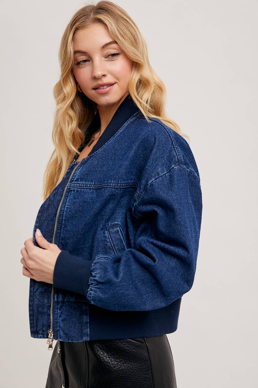 close-up of Karkata NC Boutique denim blue bomber jacket zipper and stitching