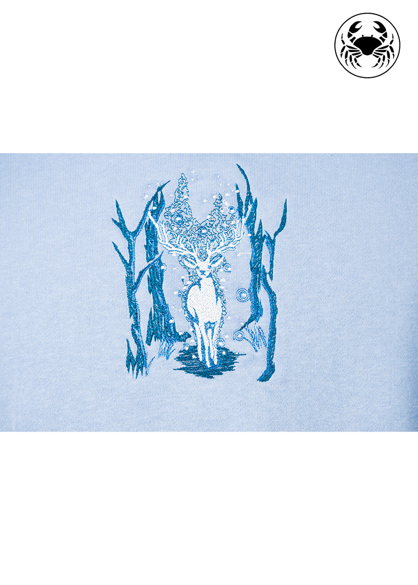 Close-up of Karkata NC Boutique sky blue sweatshirt with detailed embroidered deer in forest design