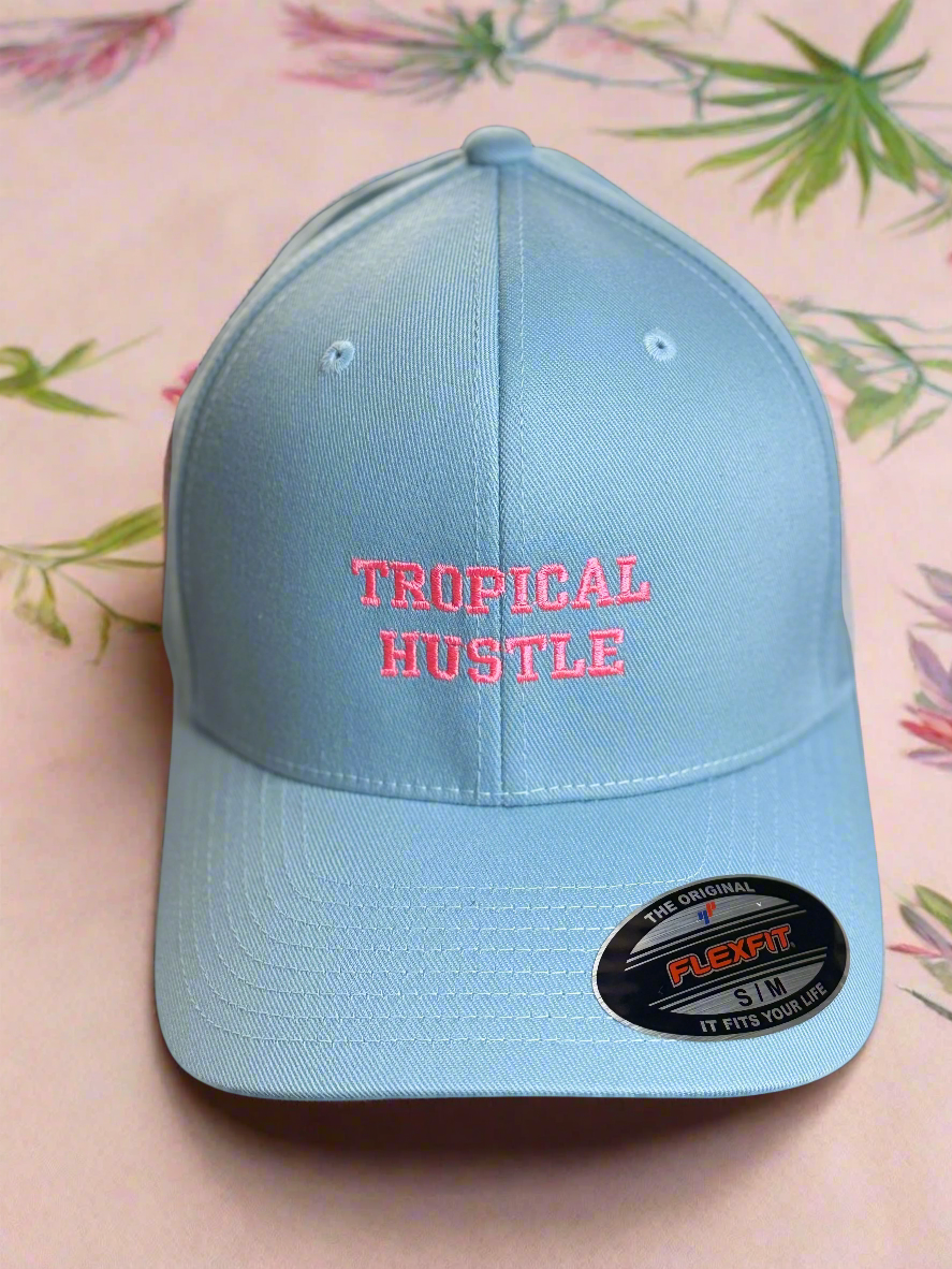 Front view of “TROPICAL HUSTLE” embroidered light blue cap with Flexfit S/M sticker